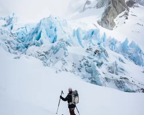 a person backcountry skiing with a raide backpack