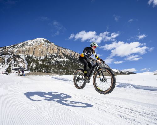 Colorado fat biking on a sunny winter day with a mountain in the background.