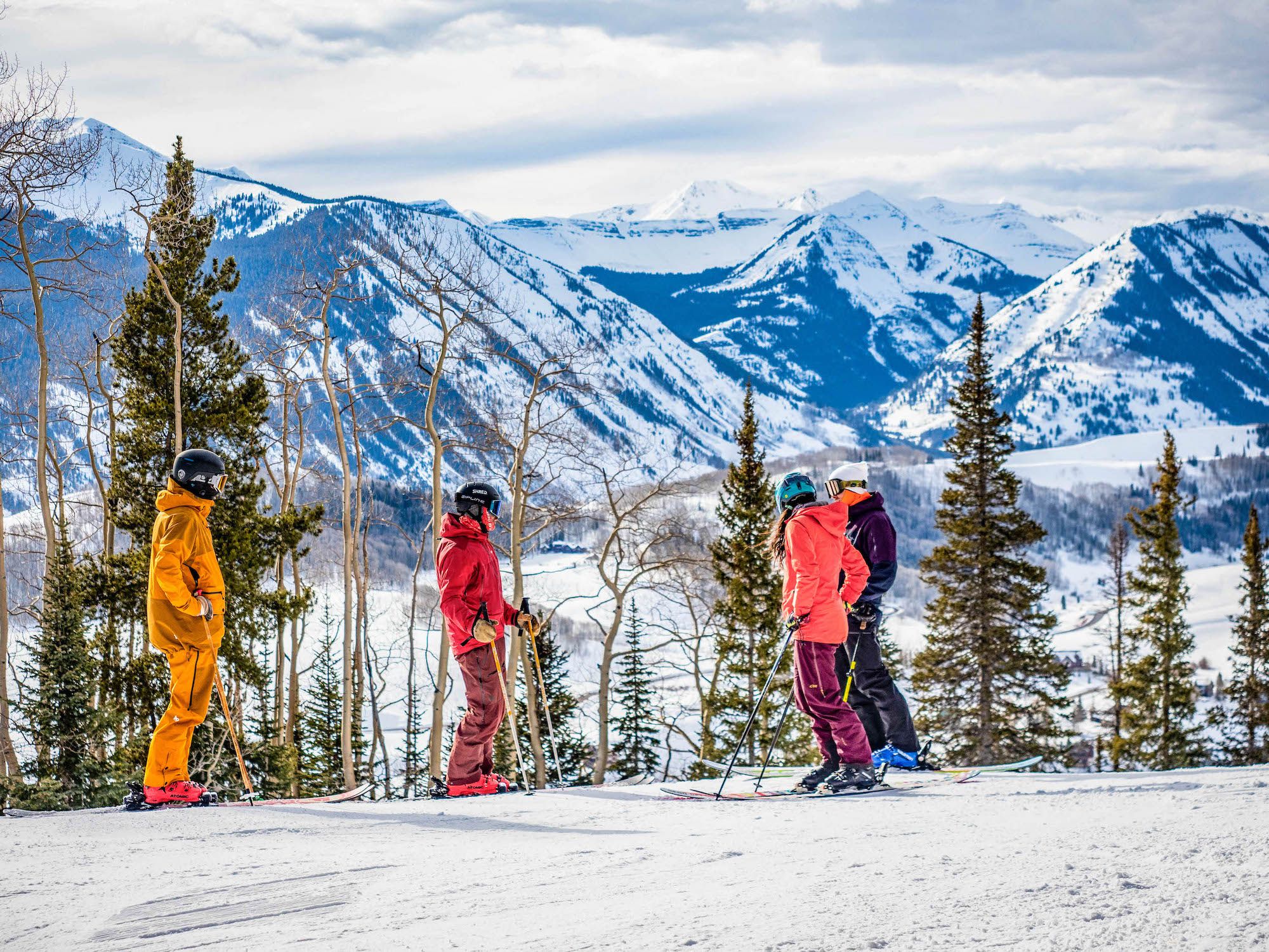 four skiers conversing on slope