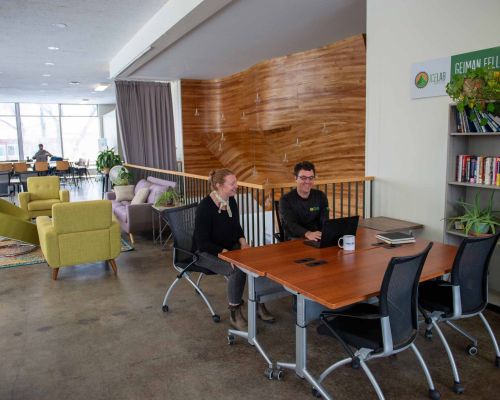 Two people sit at a desk in an open coworking space called the ICELab at Western