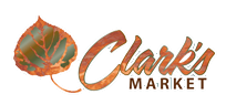 Clarks Market in Crested Butte, CO. The building has a peaked roof above a sign that says "Clark's Market." Seven large windows are under the sign.
