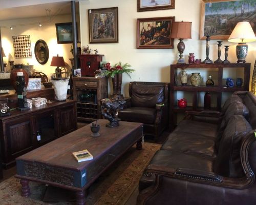 Boom-A-Rang, a thrift store in Gunnison. The picture features art on the walls, couches, a vintage coffeeshop, shelves with knickknacks and lamps.