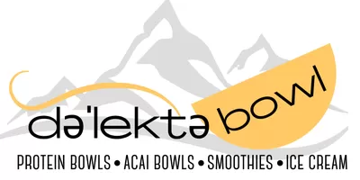 An acai bowl with granola, almond butter and blueberries from Delektabowl in Gunnison. A hand is holding the bowl up in front of a sign that reads "Delektabowl."