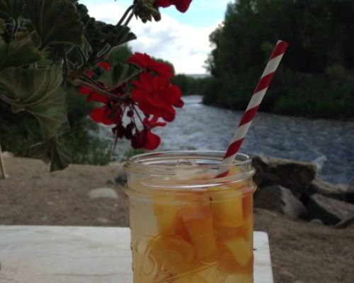 A cocktail sitting on a table next to a river at Garlic Mike's.
