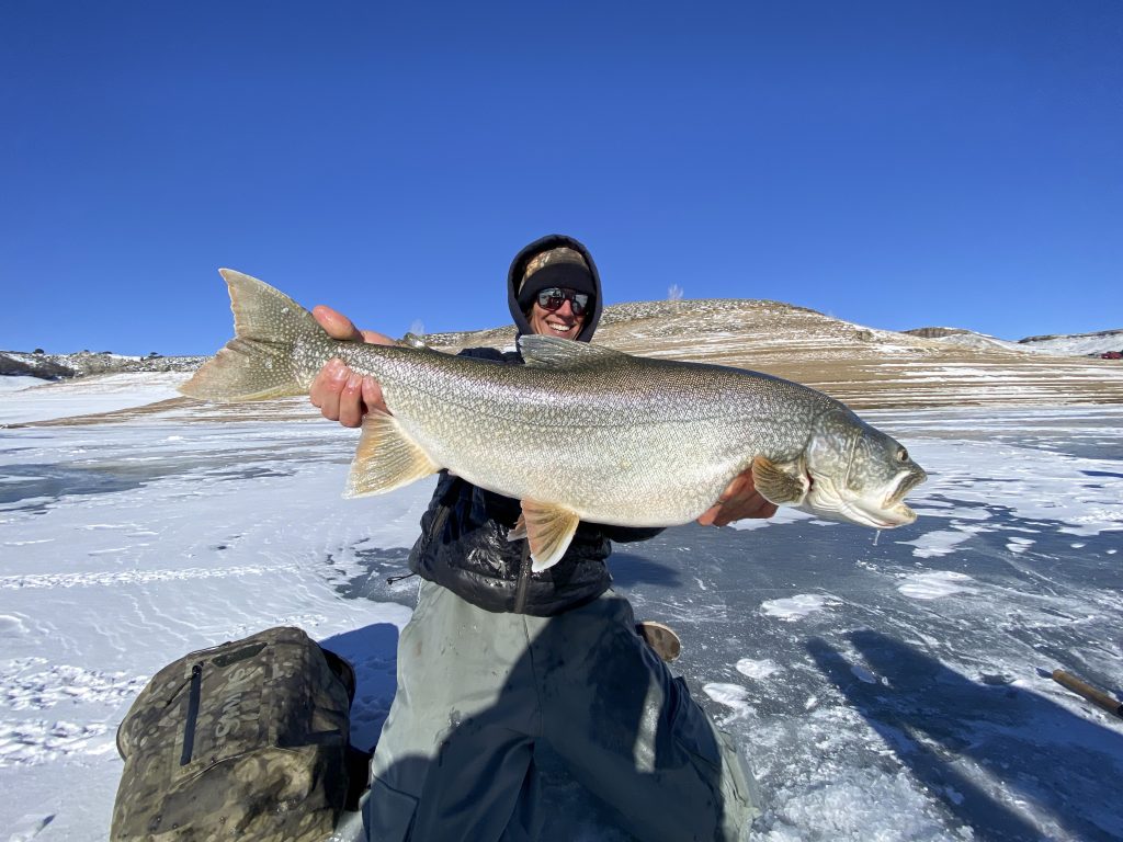 An ice fisher holds up a fish on Blue Mesa Reservoir in Gunnison, Colorado.