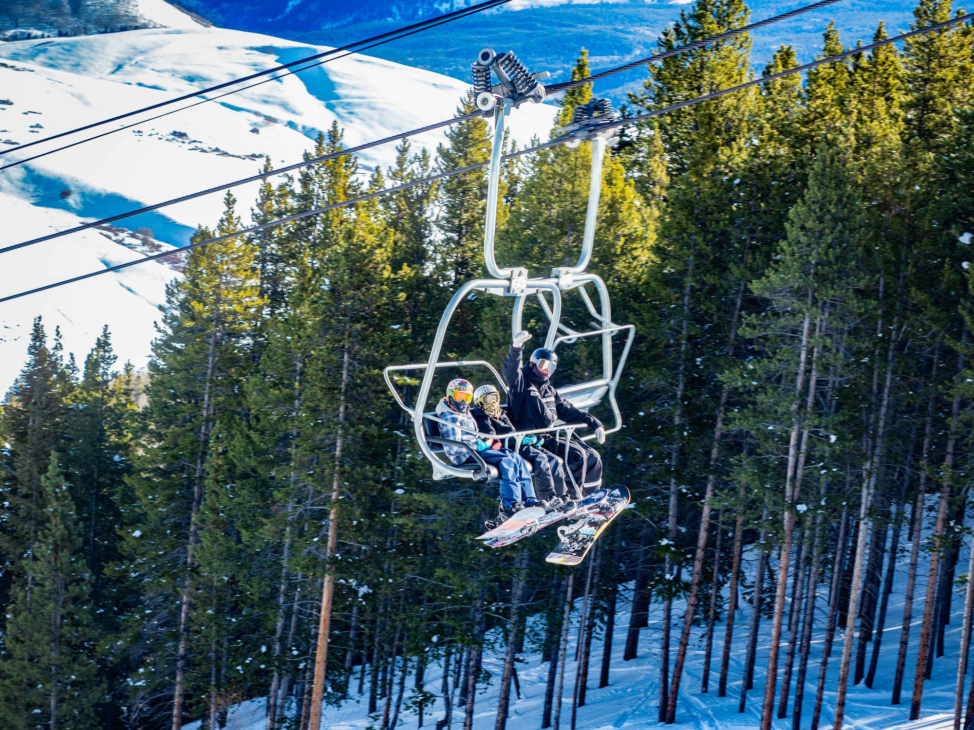 Three people riding the East River lift at Crested Butte