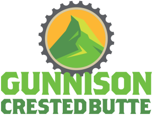 The shape of a gear with a graphic of a mountain peak in the middle of it. Beneath that it says "Gunnison Crested Butte"