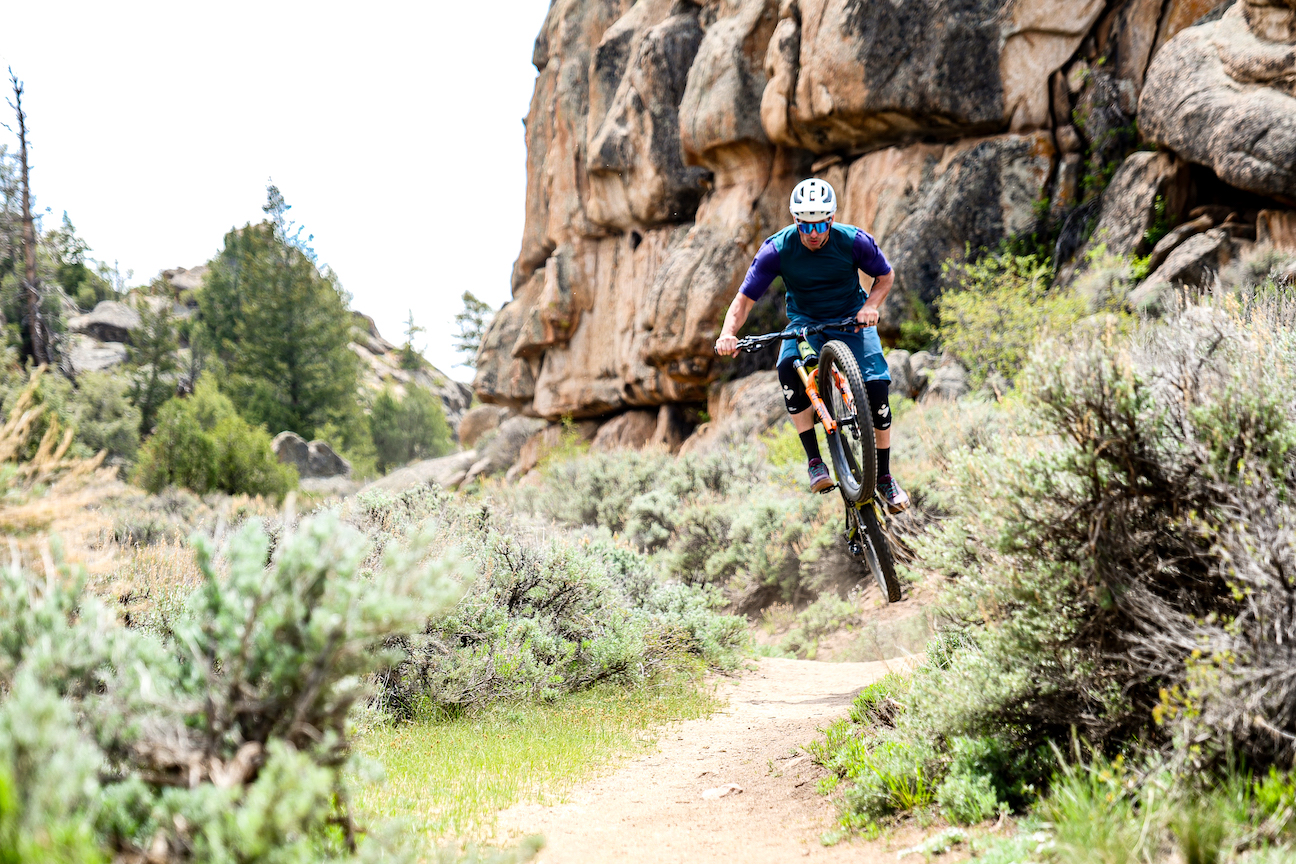 A mountain biker on a trail lined with sagebrush
