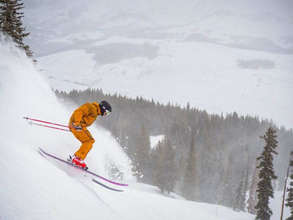 A skier in orange skies down a run at Crested Butte Mountain Resort in Crested Butte, Colorado. 