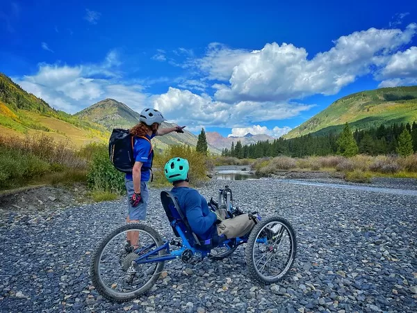 An adaptive biker gets directions on a gravel road
