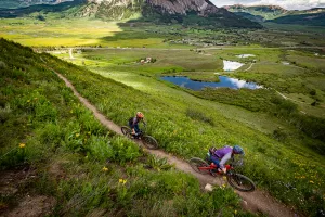 Two mountain bikers ride Baxter Gulch trail in Crested Butte in summer.