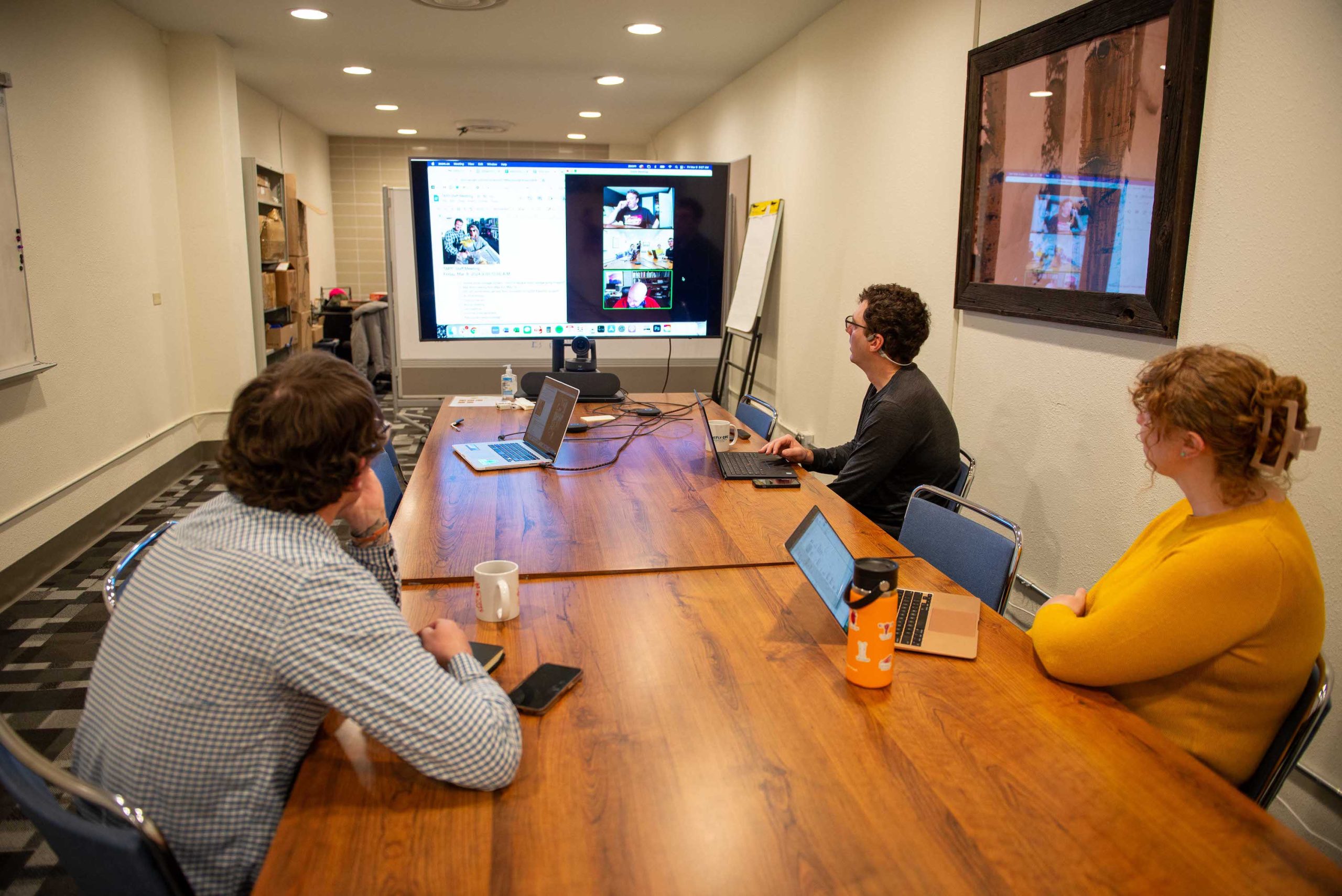 Three people sitting around a conference room at a gunnison coworking space, the ICELab at Western