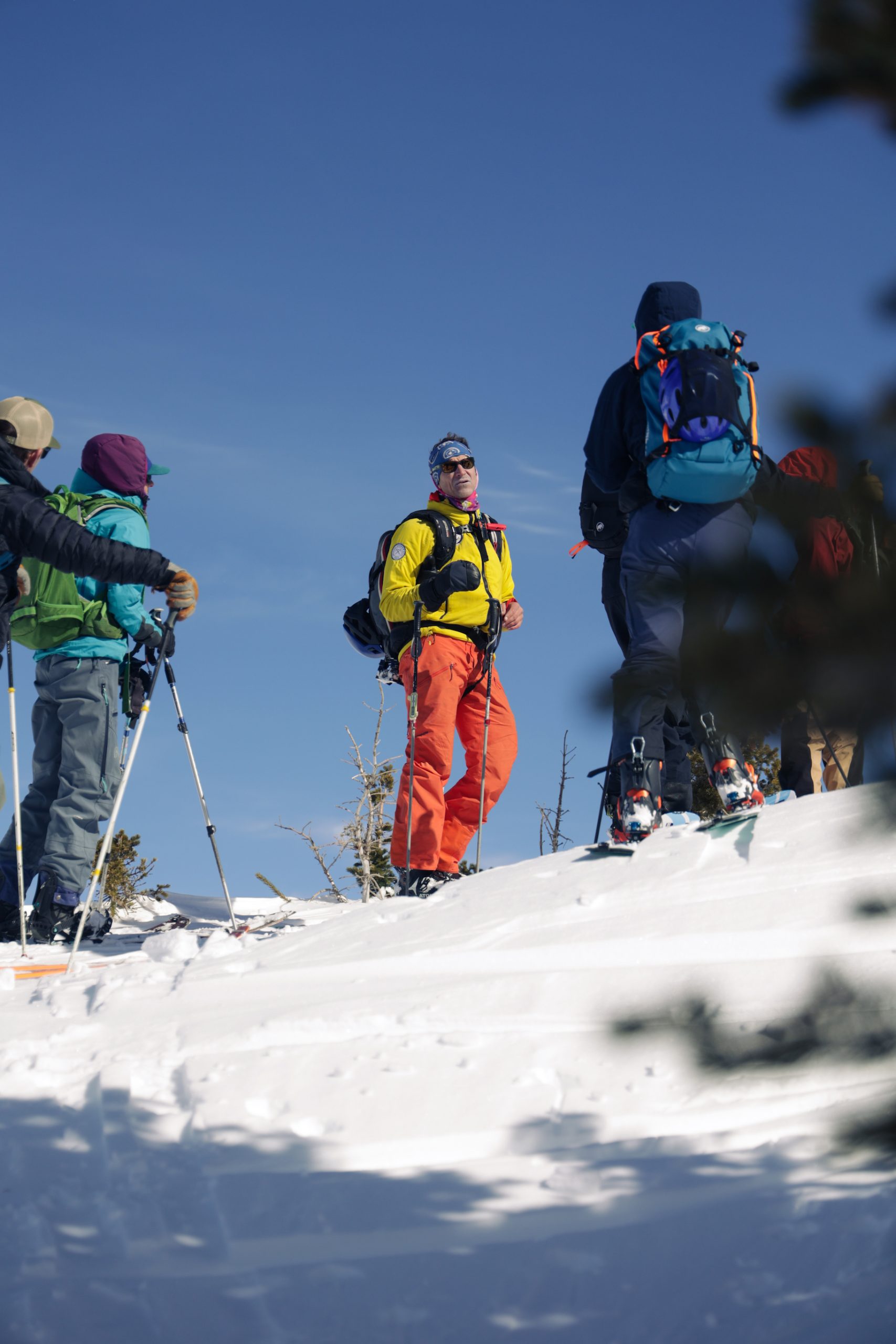 People standing and listening to a talk about crested butte backcountry skiing on a snowy slope