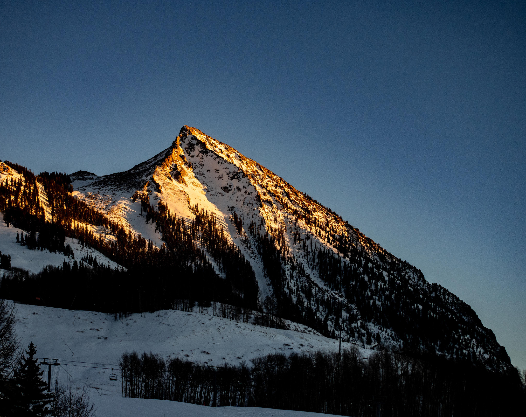 A mountain peak lit up in the sun. Crested Butte Mountain is home to Crested Butte Mountain Resort 