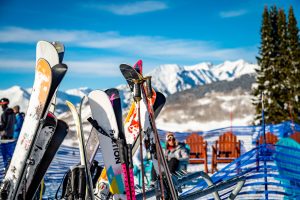 Skis stacked up in front of snowy peaks