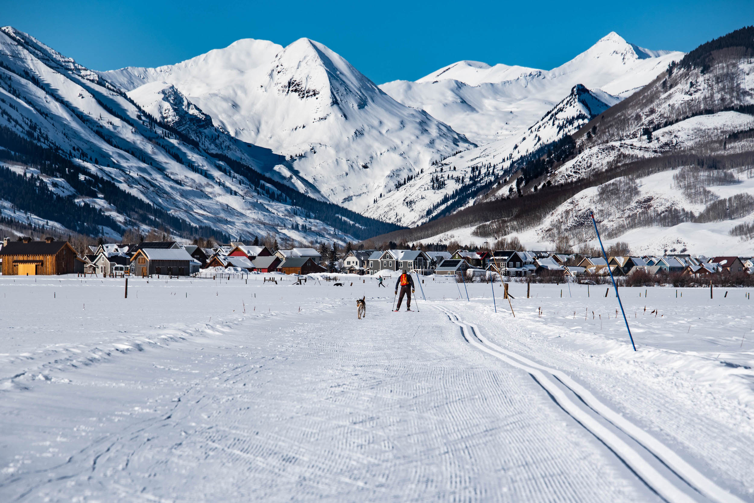 A person and a dog skiing on a Nordic track. This is one of the Crested Butte Nordic skiing areas 
