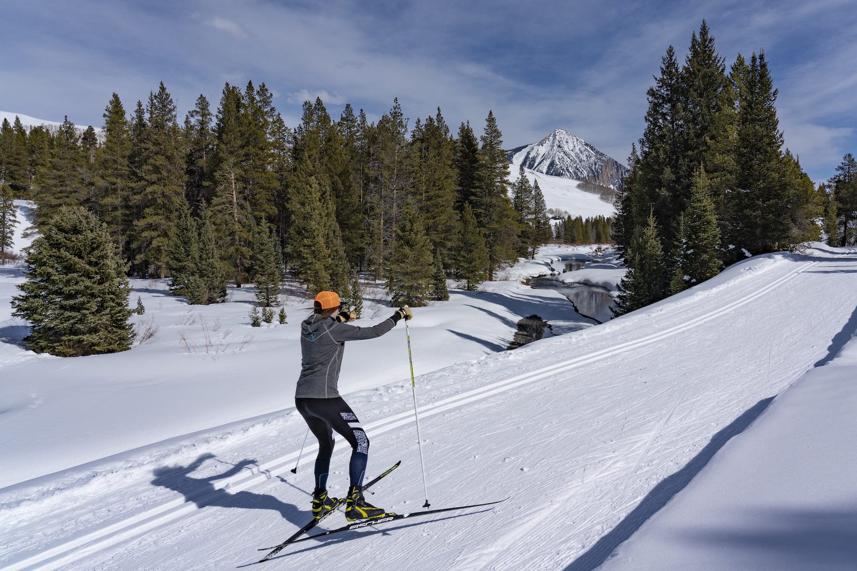 A cross-country skier skate skiing on a groomed track
