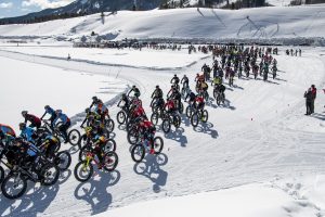 A group of racers competes in Fat Bike Worlds on a snowy track in Crested Butte.