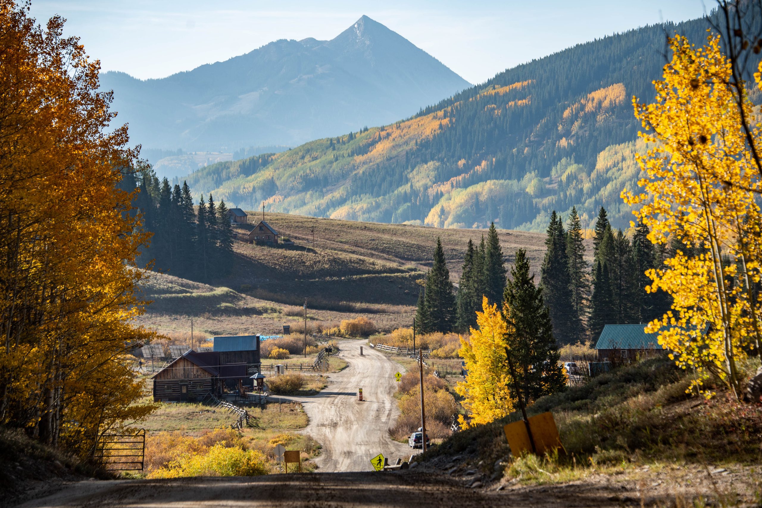 a mountain peak in the background with a road and the buildings of gothic, colorado in the foreground