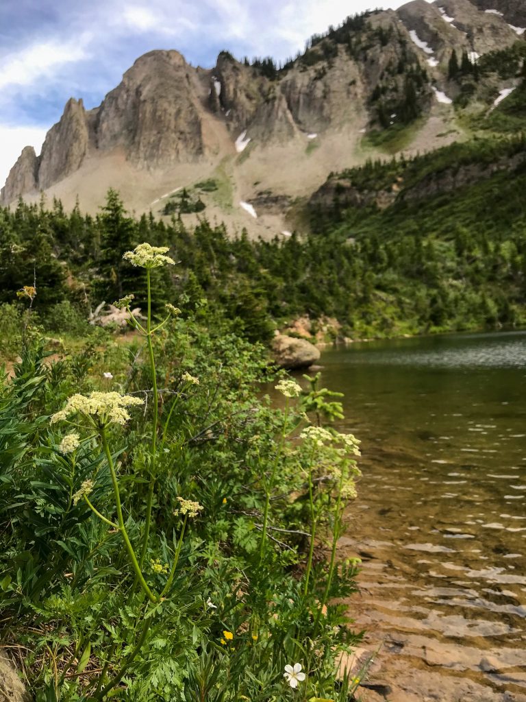 Green Lake in Crested Butte. The picture features a view of the lakeshore with mountains in the background.