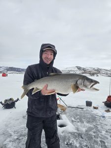 A mans holds a trophy lake trout harvested from Blue Mesa Reservoir near Gunnison, Colorado.