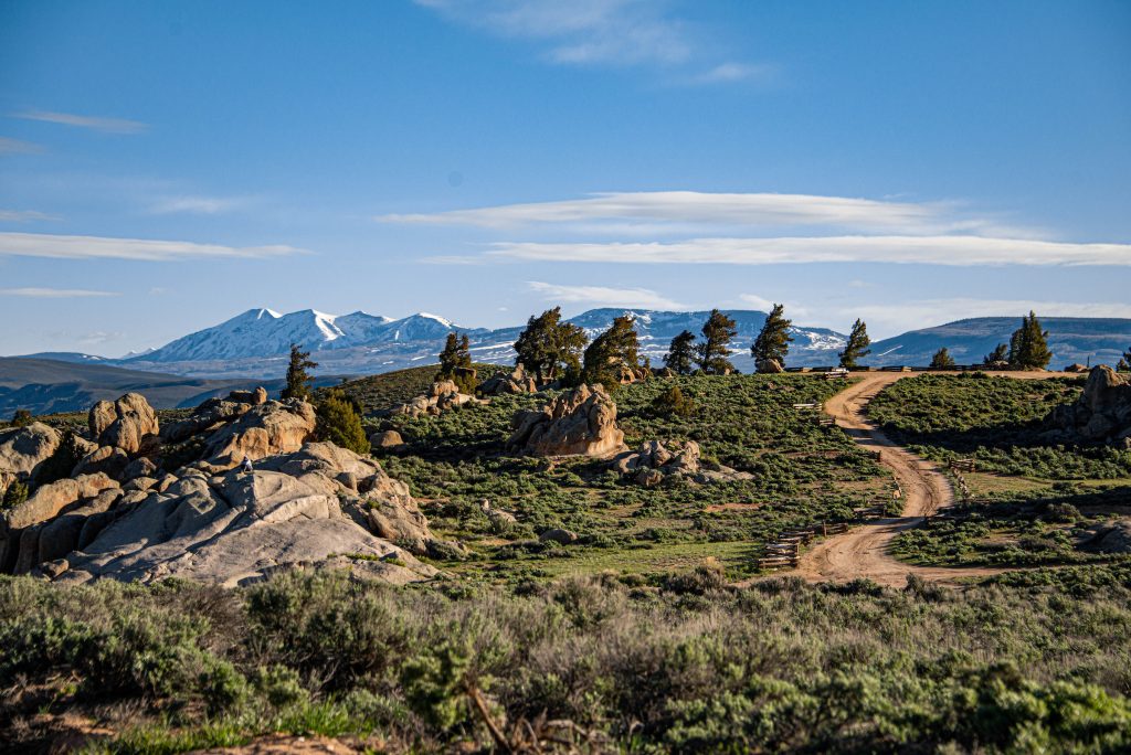 Hartman Rocks in Gunnison, Colorado. a dirt path cuts through rolling hills of sagebrush.