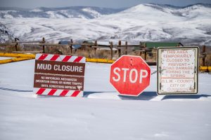 Deep snow and trail closure signs at Hartman Rocks in Gunnison during winter.