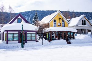 Brightly painted, snow-covered houses on a street in Crested Butte.