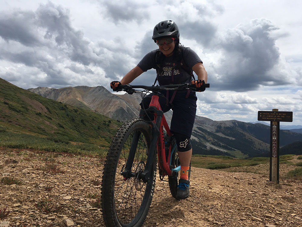 photograph showing Mel reaching the top of a climb on her mountain bike