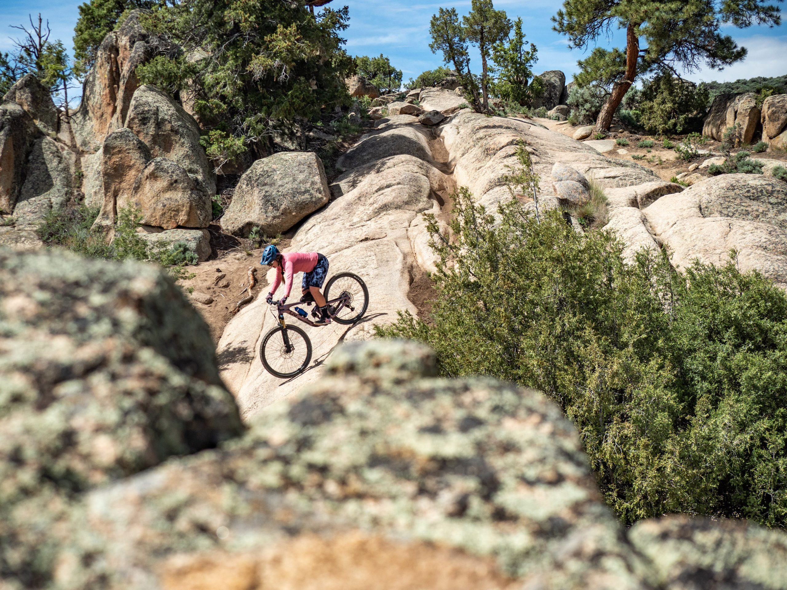 a mountain biker rides down a rocky slope
