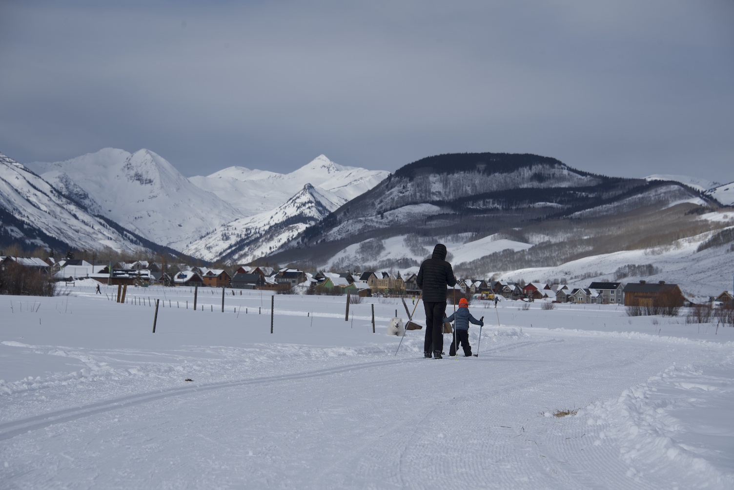 A parent and a child skiing on a nordic track. Go nordic skiing with kids in Crested Butte