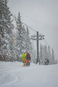 Skiers ride up the North Face Lift at Crested Butte on a snowy day.