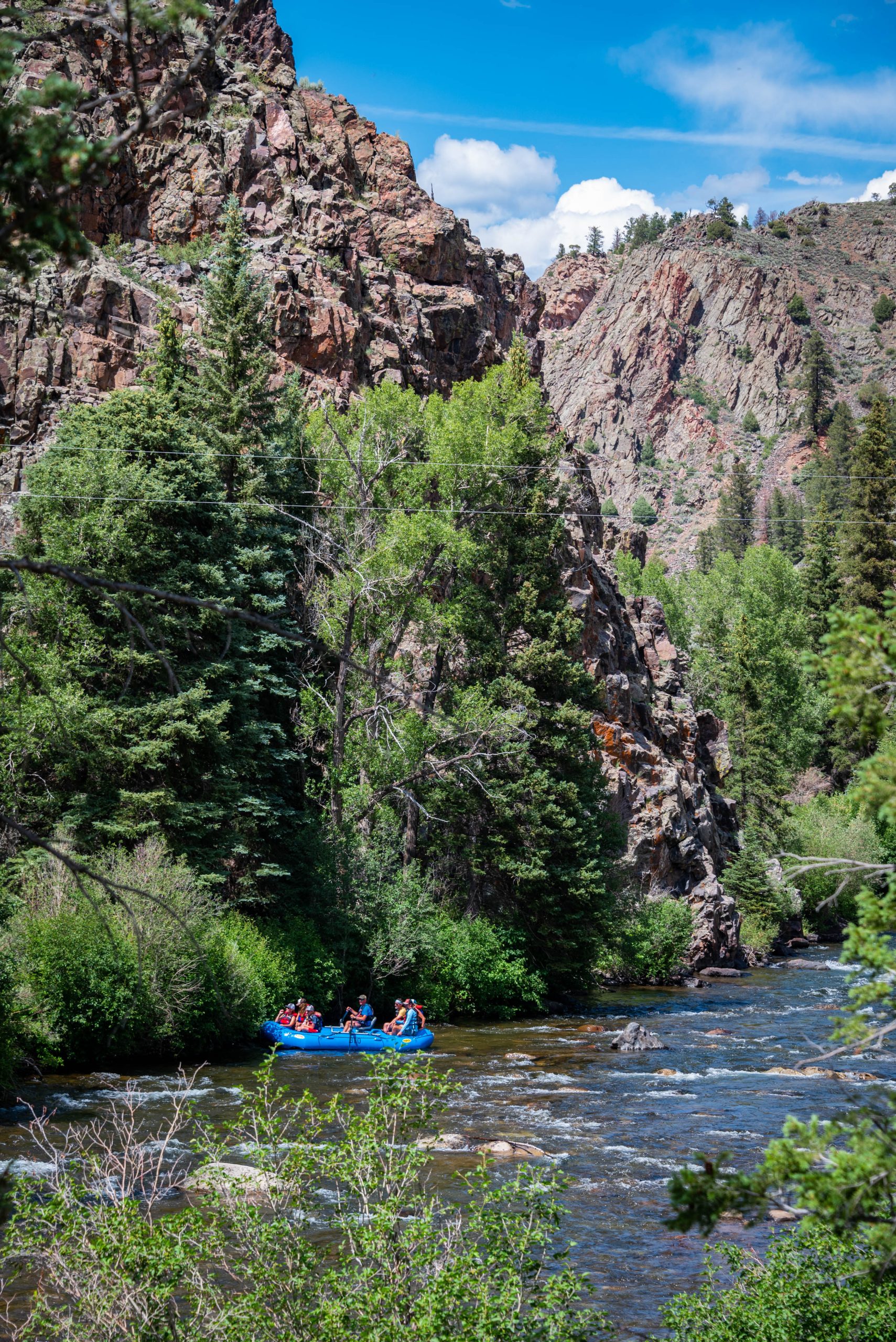 a raft floating on a river under a canyon