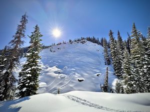 Looking up at the steep ridge of Teo 2 at Crested Butte on a sunny winter day.