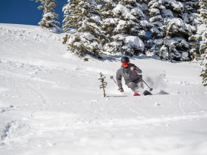 A skier skis through a few inches of fresh powder on a bluebird Colorado day in Teo Bowl.