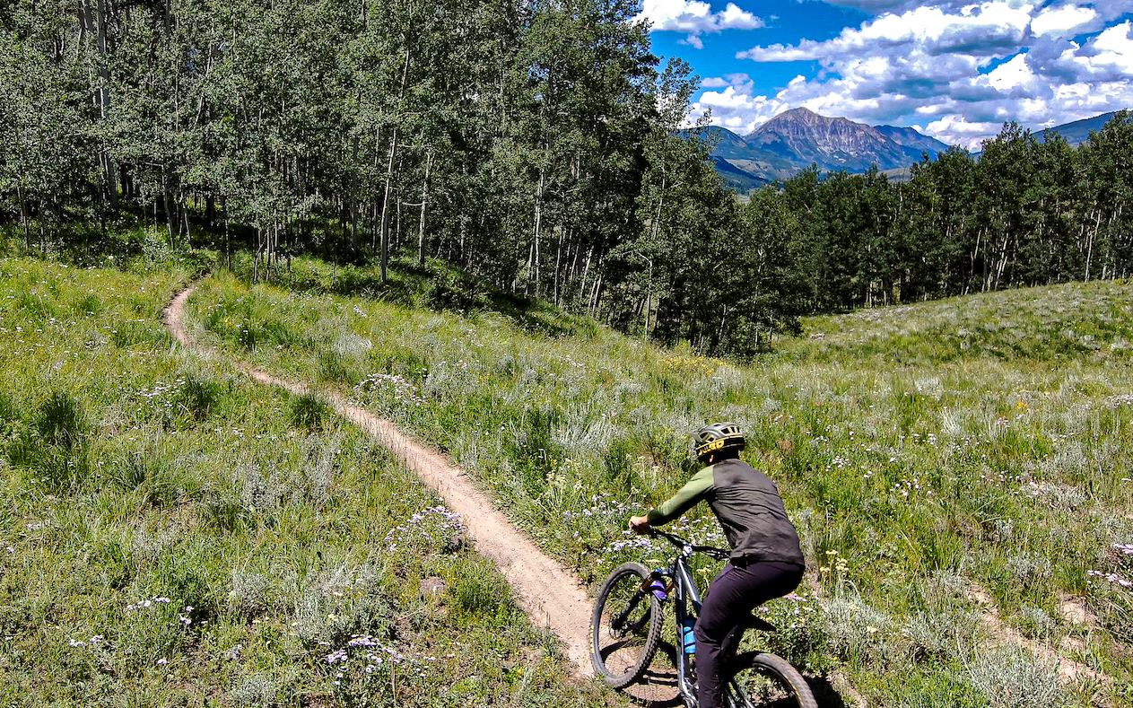 A person riding on a dirt trail. The trail is 409.5 Crested Butte