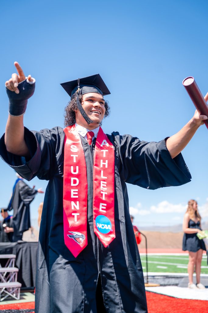 A graduate celebrates after receiving his diploma at Western Colorado University graduation