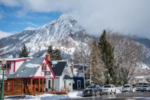 A downtown street in the winter. A mountain peak in the background obscured by fog