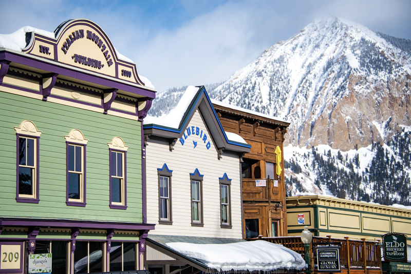 Crested Butte businesses with snowy Crested Butte (the mountain) in the background. 